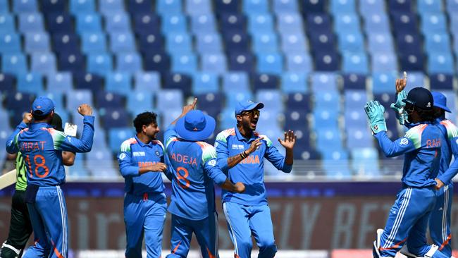 India celebrate a wicket, with plenty of empty seats in the background. (Photo by Jewel SAMAD / AFP)