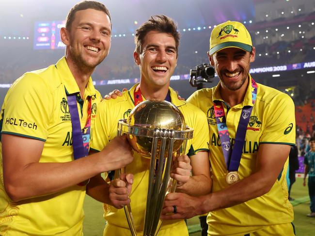 AHMEDABAD, INDIA - NOVEMBER 19: Josh Hazlewood, Pat Cummins and Mitchell Starc of Australia poses with the ICC Men's Cricket World Cup Trophy following the ICC Men's Cricket World Cup India 2023 Final between India and Australia at Narendra Modi Stadium on November 19, 2023 in Ahmedabad, India. (Photo by Robert Cianflone/Getty Images)