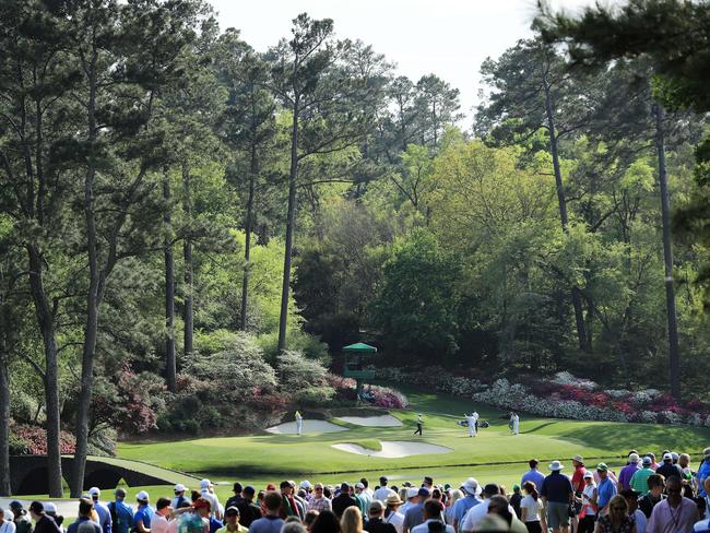 AUGUSTA, GA - APRIL 06: Patrons watch as Tiger Woods of the United States, Tommy Fleetwood of England and Marc Leishman of Australia play the 12th green during the second round of the 2018 Masters Tournament at Augusta National Golf Club on April 6, 2018 in Augusta, Georgia.   David Cannon/Getty Images/AFP == FOR NEWSPAPERS, INTERNET, TELCOS & TELEVISION USE ONLY ==