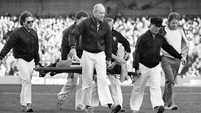 Paul Salmon is carried from the field after wrecking his knee in 1984.