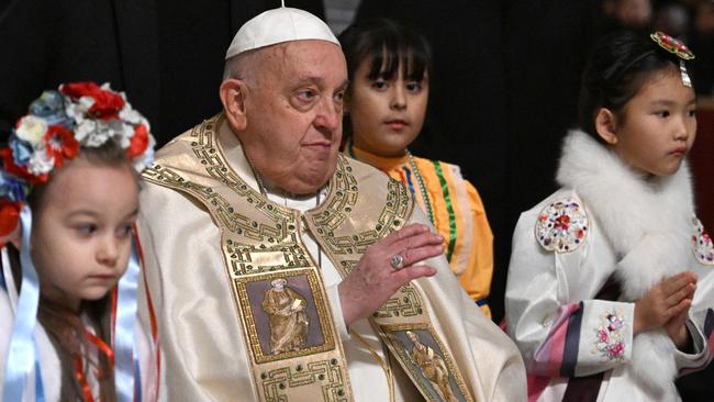 Pope Francis is surrounded by children at the end of the Christmas Eve mass at St Peter's Basilica in the Vatican on December 24, 2024. Picture: AFP.