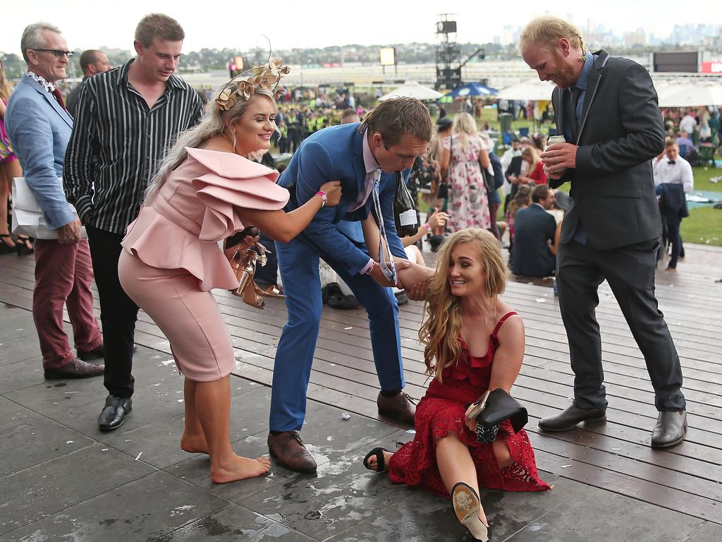 MELBOURNE, AUSTRALIA - NOVEMBER 06: Racegoers stumble as they make their way home following Melbourne Cup Day at Flemington Racecourse on November 6, 2018 in Melbourne, Australia. (Photo by Scott Barbour/Getty Images)