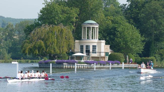 Two boats racing from Temple Island which marks the start of the course at the annual Henley Royal Regatta.