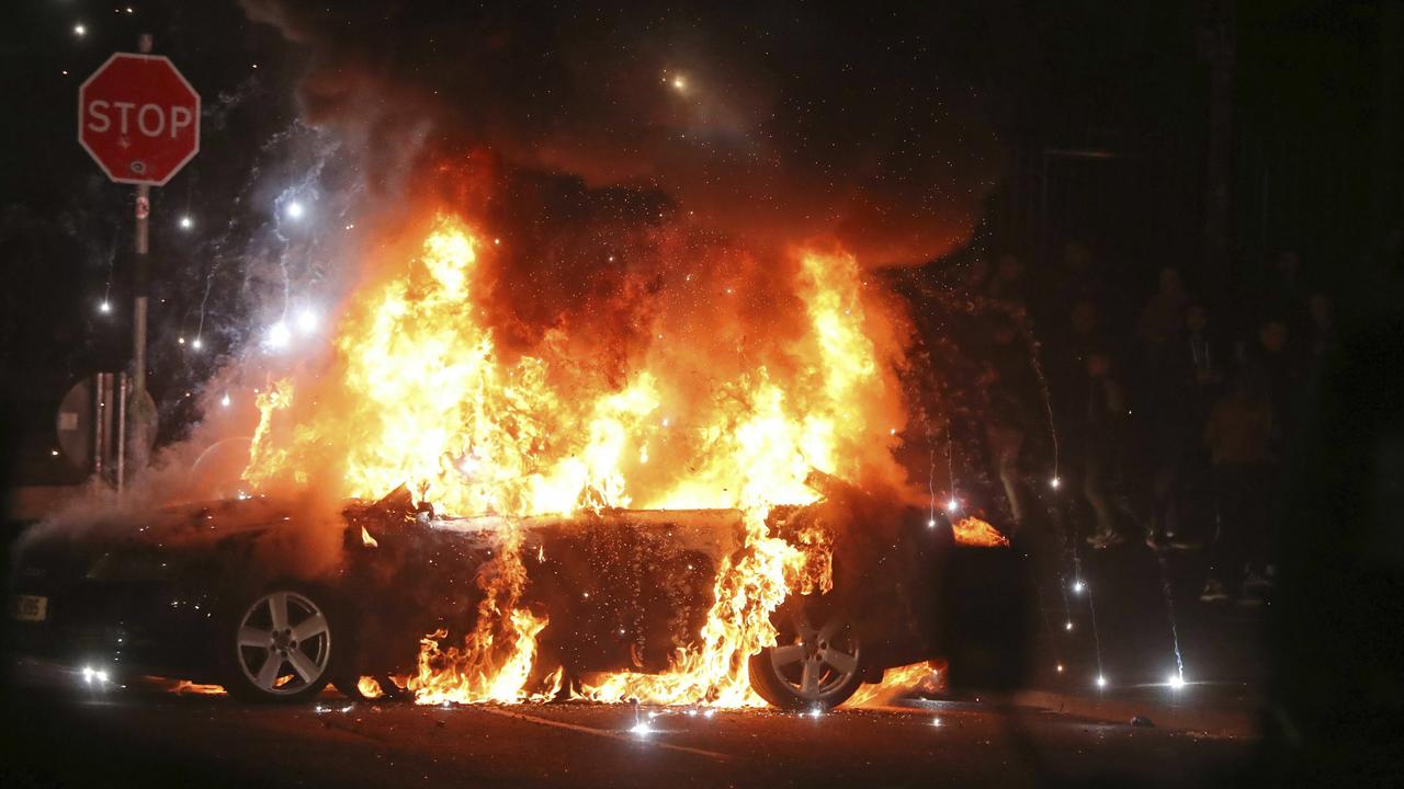 A car burns after petrol bombs were thrown at police in Creggan, Londonderry, in Northern Ireland. Picture: AP