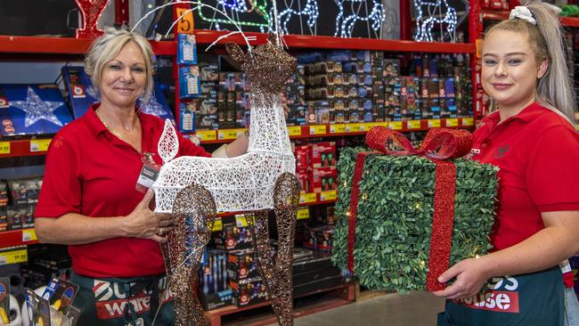 Bunnings team members Tracy Weeks and Hollie Cogill holding Christmas decorations.