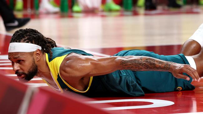 SAITAMA, JAPAN - AUGUST 05: (EDITORÃ¢â¬â¢S NOTE: Alternative crop of image #1332431086) Patty Mills #5 of Team Australia slides on the court after being fouled while driving to the basket against Team United States during the first half of a Men's Basketball quarterfinals game on day thirteen of the Tokyo 2020 Olympic Games at Saitama Super Arena on August 05, 2021 in Saitama, Japan. (Photo by Kevin C. Cox/Getty Images)