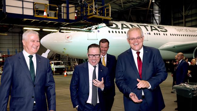 SYDNEY, AUSTRALIA – NewsWire Photos MARCH 11, 2021: Pictured Deputy Premier Michael McCormack, Qantas CEO Alan Joyce, Australian Prime Minister Scott Morrison, and behind, Minister for Tourism Dan Tehan share a laugh on the way to their press conference at Qantas Hangar 96 at Sydney Airport in Sydney NSW. Picture: NCA NewsWire / Dylan Coker