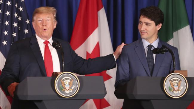 Donald Trump touches Justin Trudeau’s shoulder during the recent signing of a trade deal, but the US president has failed to voice support for his neighbour. Pic: AP