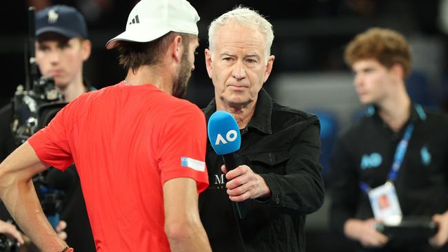 John McEnroe holds the mic at the Aussie Open. Photo by Kelly Defina/Getty Images.