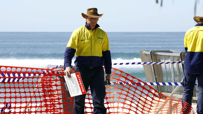 Gold Coast council workers remove the barricades at Surfer Paradise, opening the beaches after the coronavirus caused closure of beaches. Picture: Tertius Pickard