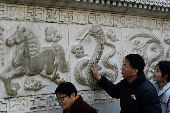 A man touches the snake figure at the Baiyun Taoist Temple in Beijing. The Year of the Snake symbolises wisdom and vitality in Chinese culture