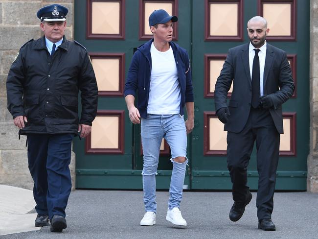 Curtis walking out of jail between two staff. Picture: AAP Image/Lukas Coch