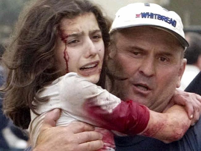 SEPTEMBER 3, 2004 : Two men carry young hostages, Zarina Dziova (L), who managed to escape from the school building after special forces entered the school in Beslan, North Ossetia, 03/09/04. Streams of hostages fled the besieged school in Beslan in southern Russia amid intensive shooting & a series of powerful explosions that signalled a bloody end to the three-day stand-off with terrorists. Crime / Terrorism / Terrorist