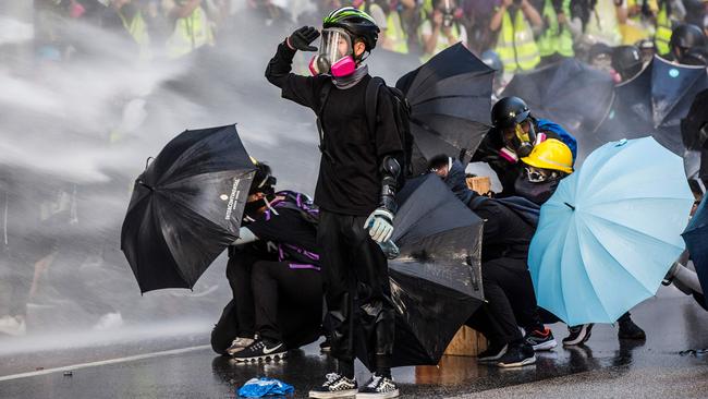 Pro-democracy protesters under fire from police water cannons in Hong Kong. Picture: AFP