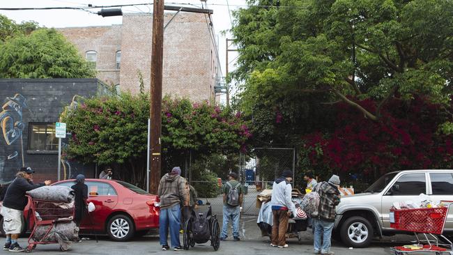 Homeless people from the surrounding Skid Row neighbourhood wait outside Hippie Kitchen. Picture: Angus Mordant/NewsCorp Australia