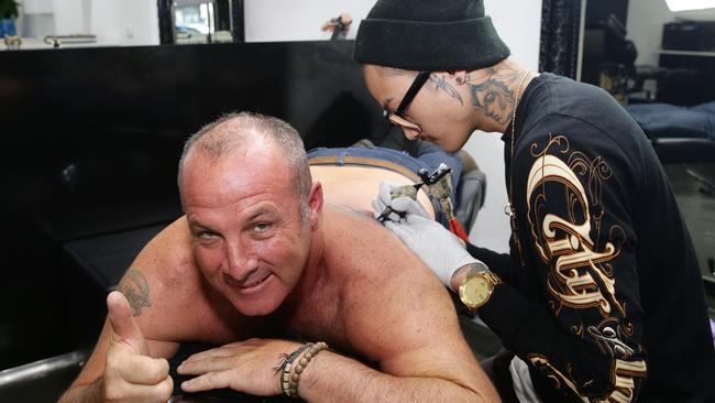 Stuart O’Neill gets a tattoo celebrating Richmond’s win at City of Ink in South Melbourne by tattoo artist Karlo Escuadro. Picture: Andrew Tauber