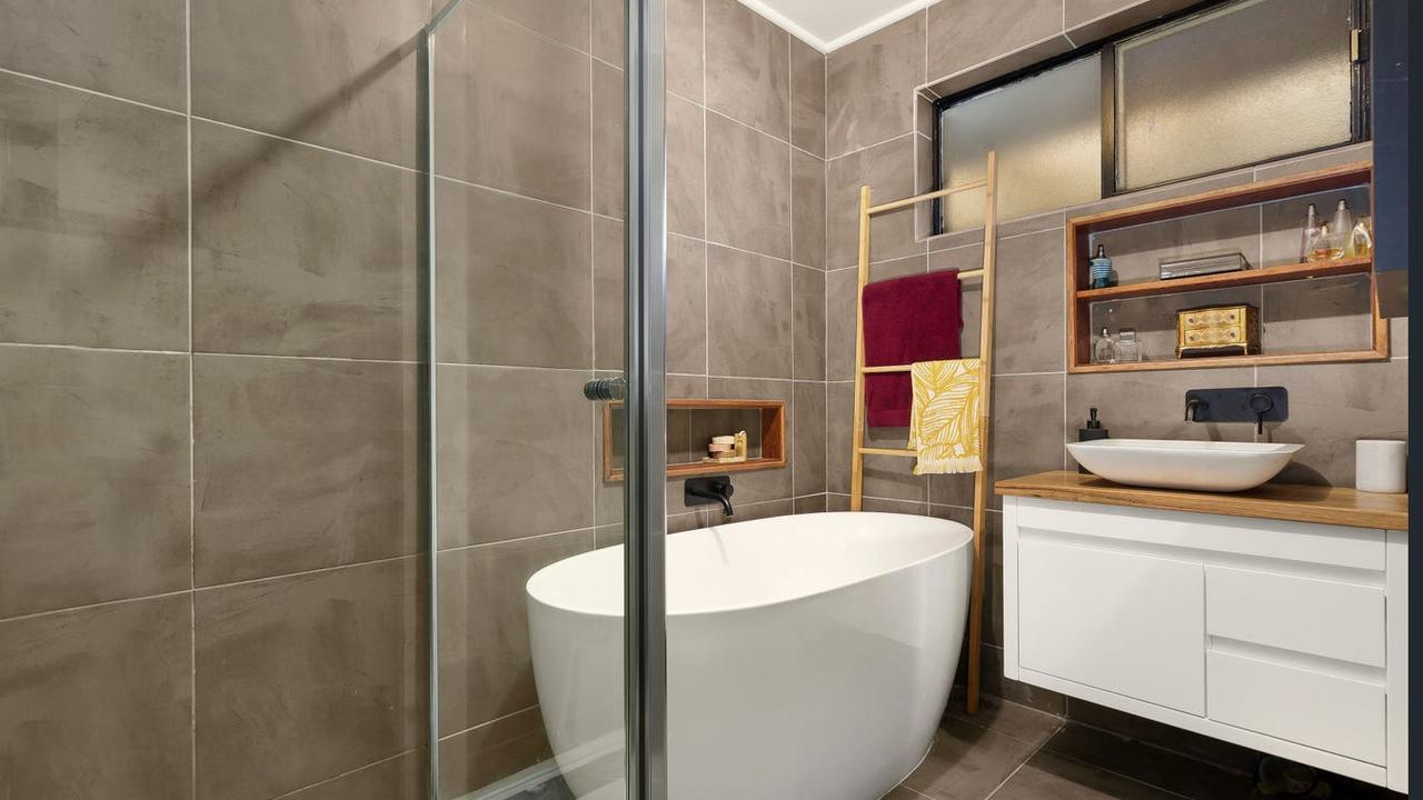 The bathroom features a freestanding tub.