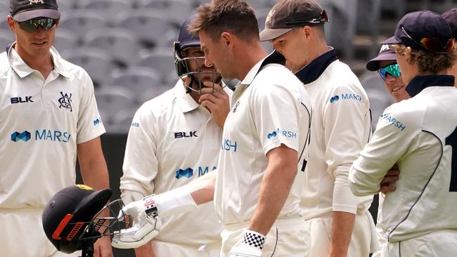 Marsh inspects his helmet after a blow to the head.