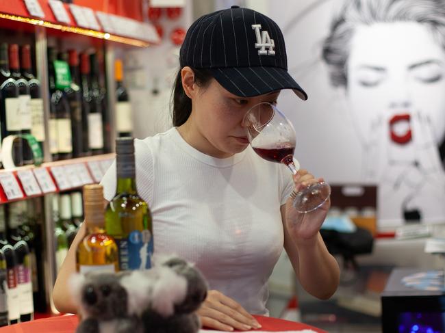 Shao Yi (white tee-shirt) buying Australian red wine at Cheers, a wine store in east Beijing., , Picture: Li Xiaonan