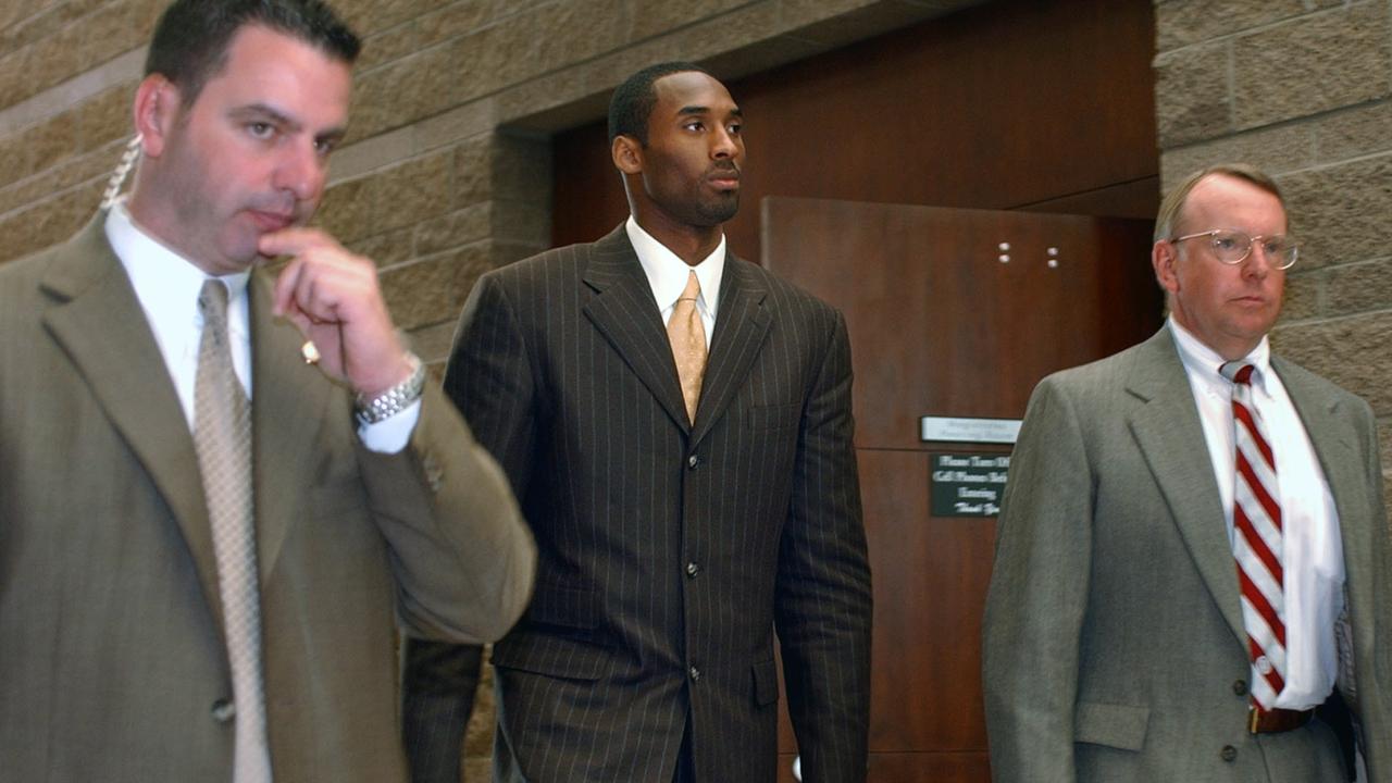 Kobe Bryant leaves proceedings in his sexual assault case as members of his security team accompany him in 2004. Picture: AP Photo/Ed Andrieski