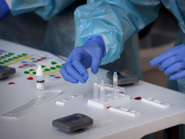 MELBOURNE, AUSTRALIA - NewsWire Photos AUGUST 03, 2021: Medical staff handle rapid Covid tests being performed on Victorian state MPs on the front steps of parliament house in Melbourne. Picture: NCA NewsWire / Andrew Henshaw