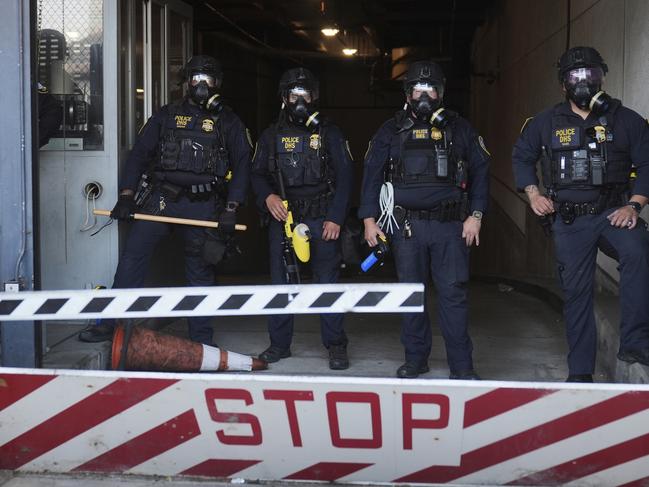 Department of Homeland Security police officers stand during a protest after federal immigration authorities conducted an operation. Picture: AP