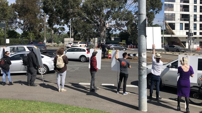 Protesters with their placards outside Flemington Racecourse. Picture: Aneeka Simonis