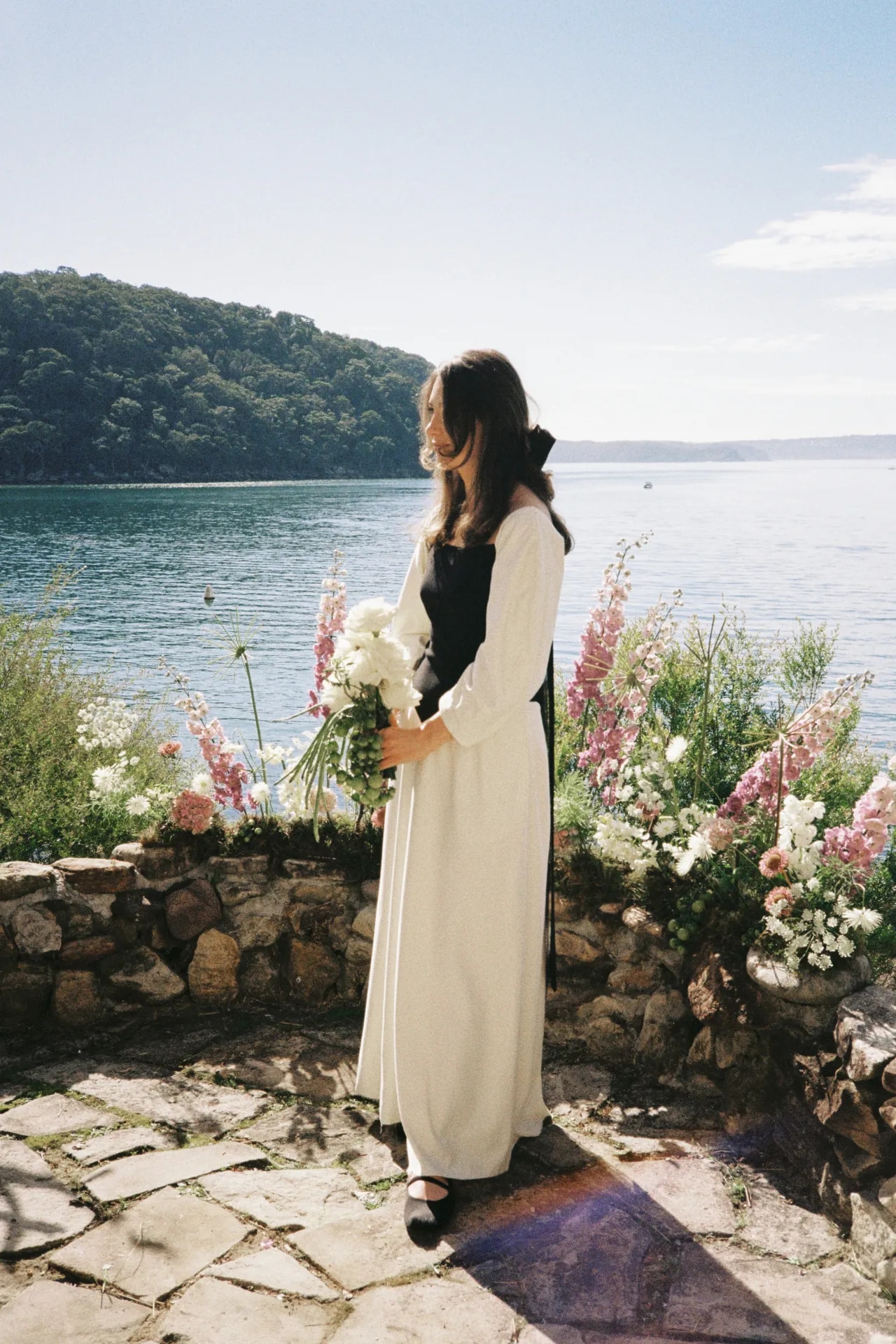 <p><em>Image credit: Jessica Tremp/Brown Paper Parcel Photography. From <a href="https://www.vogue.com.au/fashion/news/sarah-kourim-james-hudson-wedding/image-gallery/f0f0c343bf4bbd0e400540151a164569" target="_blank" rel="noopener">This fashion designer eloped in Gabriela Hearst for her charming, Peloponnesian seaside ceremony</a></em></p><h2>Sarah Kourim in Gabriela Hearst</h2><p>&ldquo;I knew I didn&rsquo;t want to wear all-white, so when I saw the Gabriela Hearst dress, I knew it was the one. &ldquo;I loved the silhouette, and its merino black bodice also made it feel more relaxed and went back with James&rsquo;s look. I paired the big floor-length bow, made by my mum, with Simone Rocha heart pearl earrings and some ballet flats from my local ballet store.&rdquo;</p>