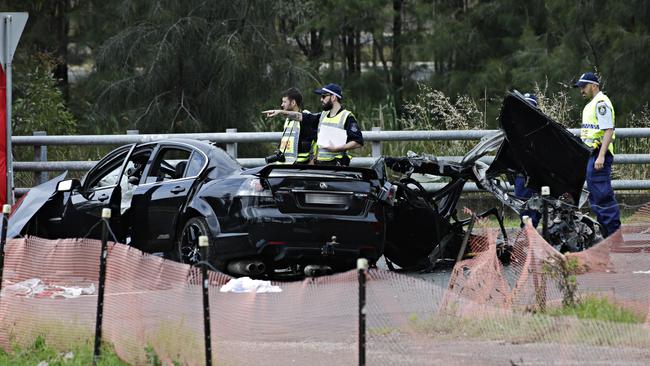 Police inspect the crash wreckage. Picture: Adam Yip