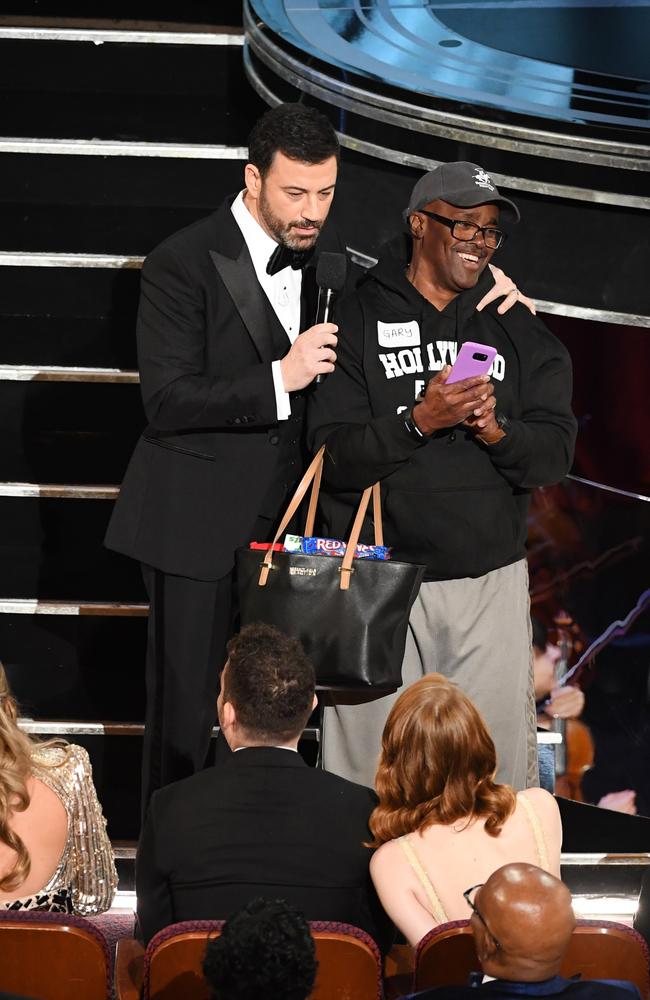 Host Jimmy Kimmel surprises tourist Gary Coe with a look inside the Oscars. Picture: Kevin Winter/Getty Images