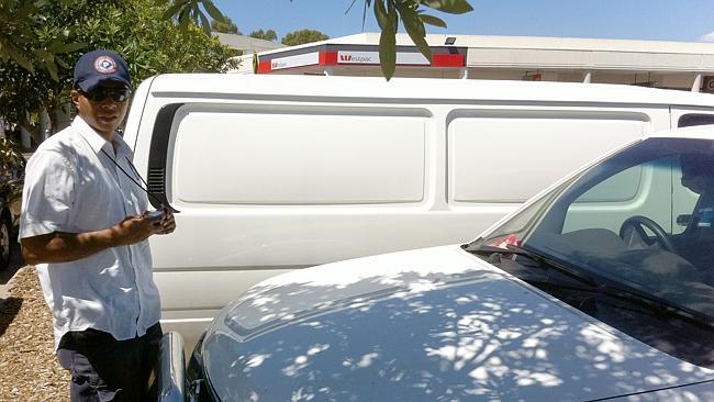 An employee of Australian National Car Parks, who would not give his name, issuing a penalty notice at Newington Marketplace....