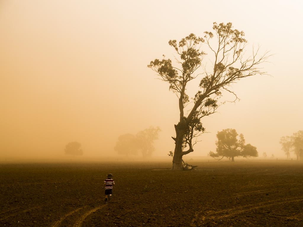 Edward Cox, 5, seen in a dust storm. His father Brad Cox is the fourth generation farmer on his family's property near Collie, north of Dubbo. Currently in the midst of the worst drought their worst drought on record, they farm sheep, cattle and grain. Picture: Dylan Robinson