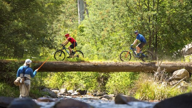 Mountain bikers cross the Delatite River near Mt Buller. Picture: Visit Victoria