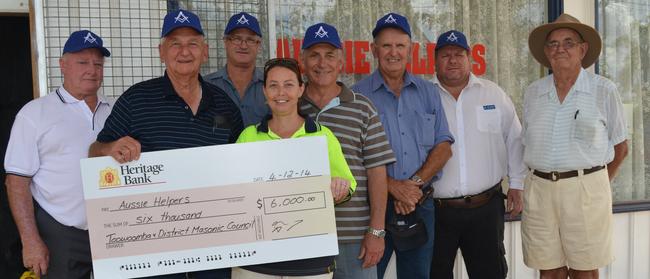 Members of the Toowoomba and District Masonic Council Jack Wright, Max Wilkins, Neil Mark, John Della, Dave Walters and Toby Brown present Aussie Helpers Sam Price with $6000 from their fundraising in 2014. Photo: Ali Kuchel.