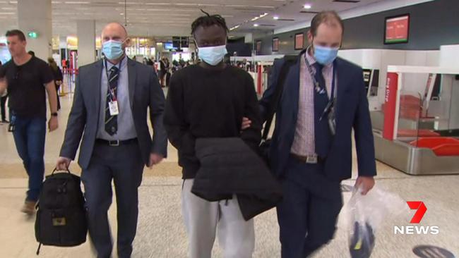 Mathiang Malok, centre, was extradited to Adelaide following his arrest. Picture: 7NEWS.