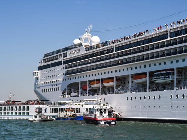 Carabinieri Police and the port's fire rescue service assist the damaged River Countess tourist boat after it was hit by the MSC Opera cruise ship in Venice. Picture: AFP