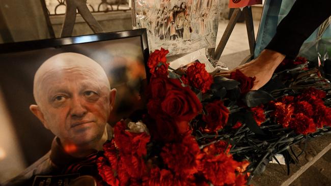 A man lays flowers at the makeshift memorial in honour of Yevgeny Prigozhin and Dmitry Utkin in Moscow. Picture: AFP.