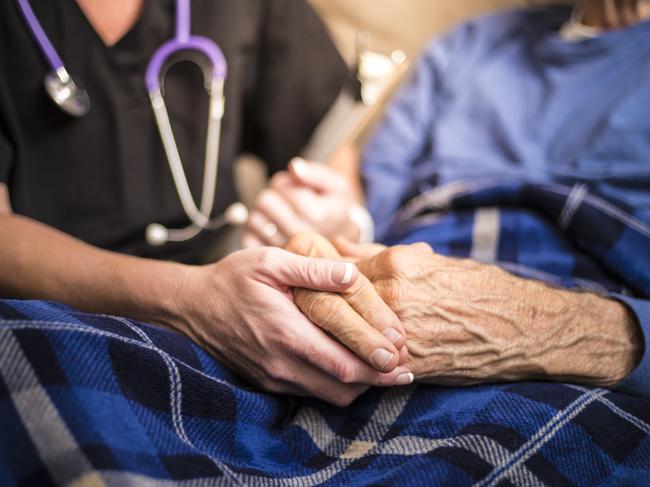 A stock photo of a Hospice Nurse visiting an Elderly male patient who is receiving hospice/palliative care. old age. Istock