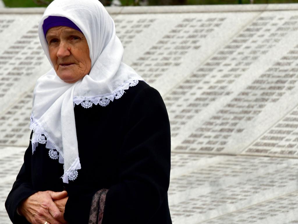 A Bosnian Muslim woman, walks by the memorial wall containing the names of the victims at the Srebrenica memorial. Picture: AFP