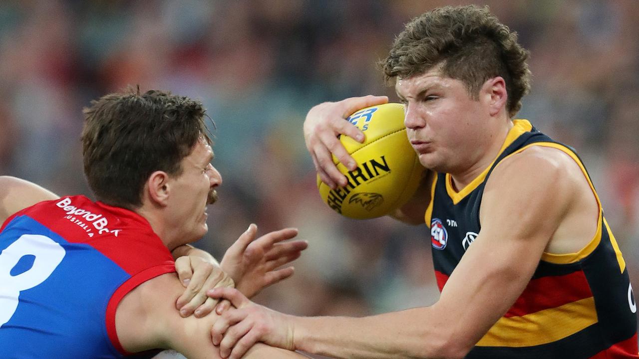 Harry Schoenberg busts through a Jake Lever tackle. Picture: Sarah Reed/AFL Photos via Getty Images