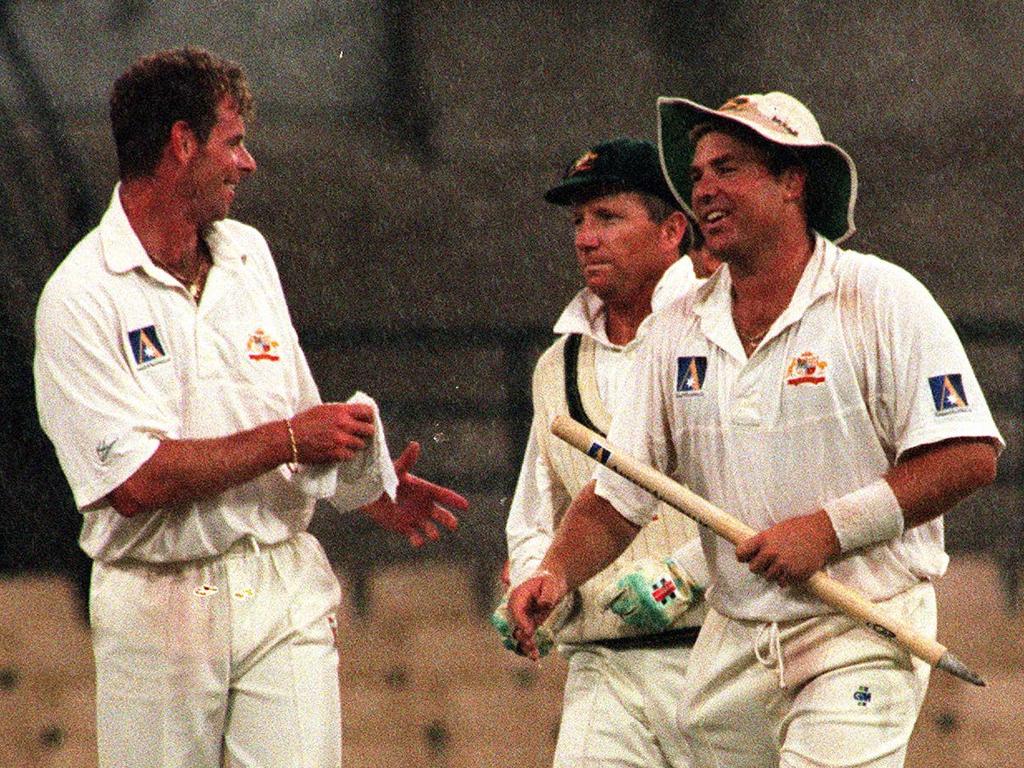 The late Shane Warne participating in the tradition of souvineering a stump at the end of a Test match.