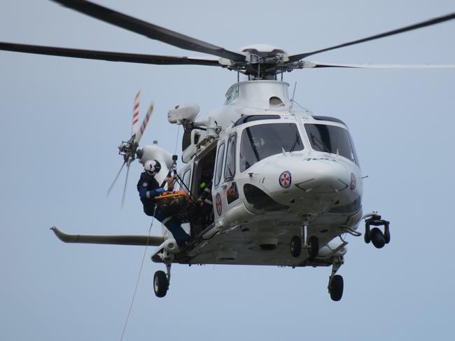 A doctor, in his 60s, was winched from rocks at Forresters Beach by the Toll rescue helicopter after crashing his paraglider. Picture: Richard Noone