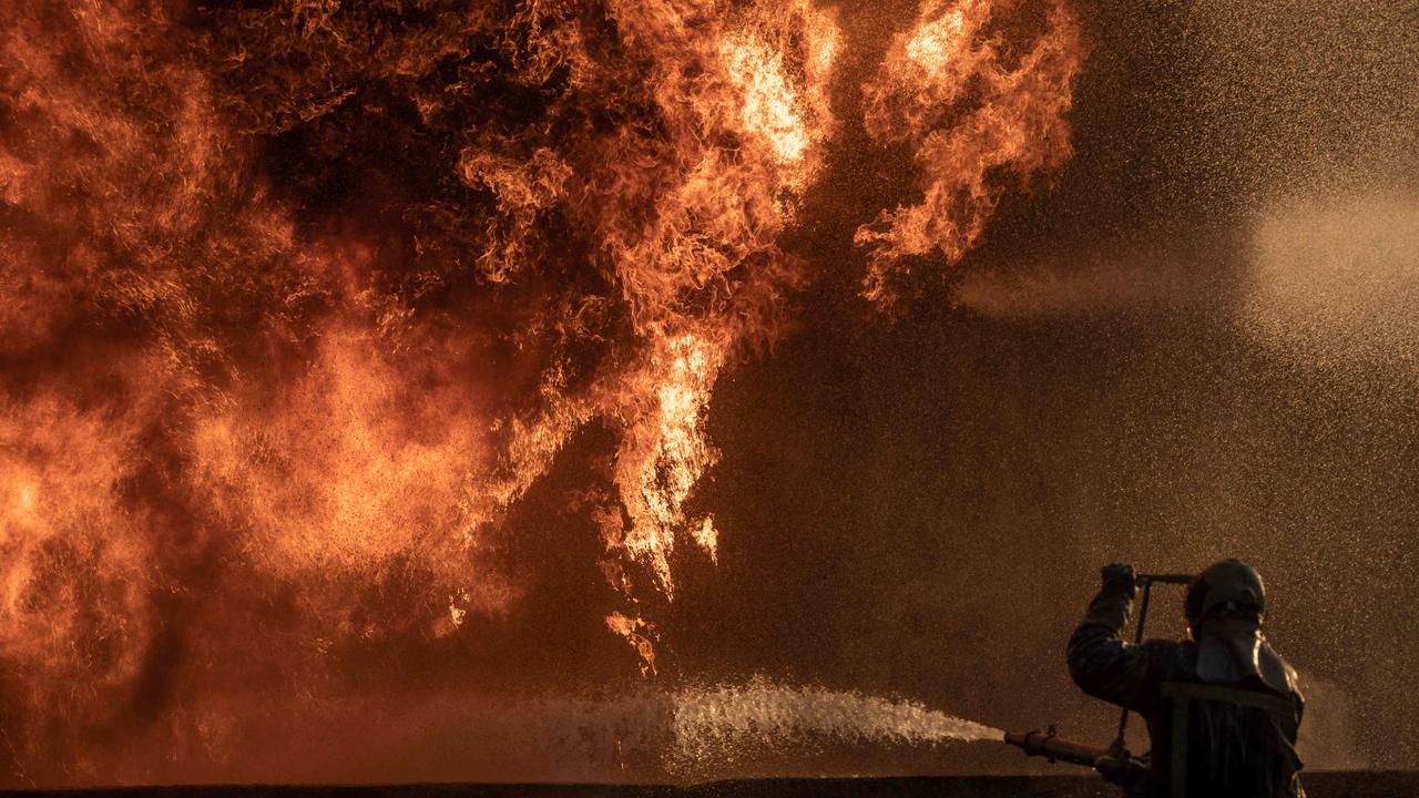 A Ukrainian firefighter trying to stop a fire at an industrial facility damaged following an air strike, in the Kyiv region, amid the Russian invasion of Ukraine. Picture: AFP.