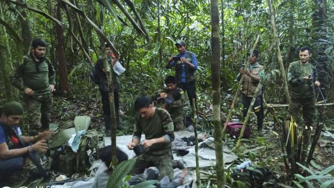 Members of the army assist four indigenous children who were found alive. Picture: AFP