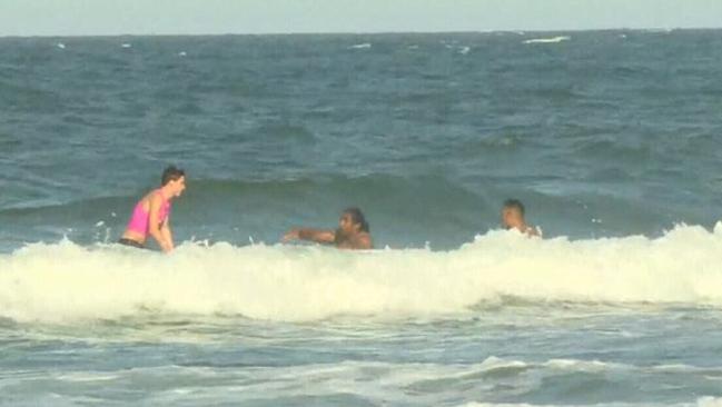 Sia Soliola being rescued from the surf.