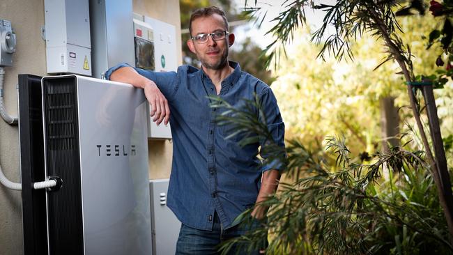 Solar Quotes founder and CEO Finn Peacock alongside his Tesla battery storage unit at his house in Brighton. Photo: Kelly Barnes