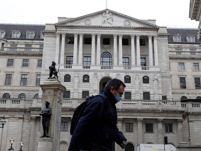 A man wearing protective face mask walks past the Bank of England in the City of London on March 30, 2020, as life in Britain continues during the nationwide lockdown to combat the novel coronavirus pandemic. - Life in locked-down Britain may not return to normal for six months or longer as it battles the coronavirus outbreak, a top health official warned on Sunday, as the death toll reached passed 1,200. (Photo by Tolga AKMEN / AFP)