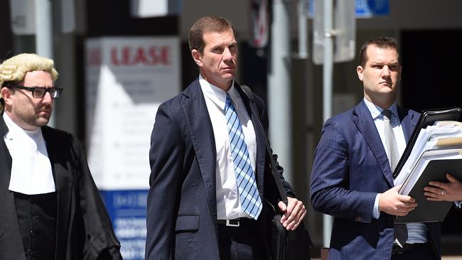 Former Billabong boss Matthew Perrin (centre) arrives for the start of his trial on Monday. Pic: AAP Image/Dan Peled