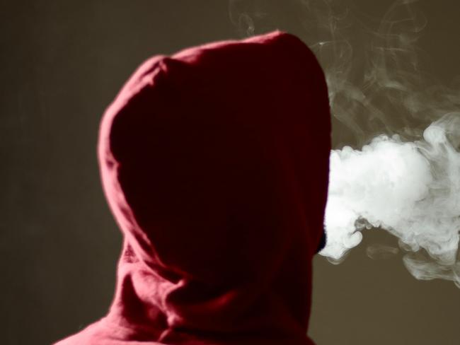 Young male in red hoodie vaping smoking, exhales thick vapor, isolated rear view Picture: iStock