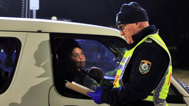 A police officer checks a motorist crossing into NSW in Albury. Picture: Aaron Francis